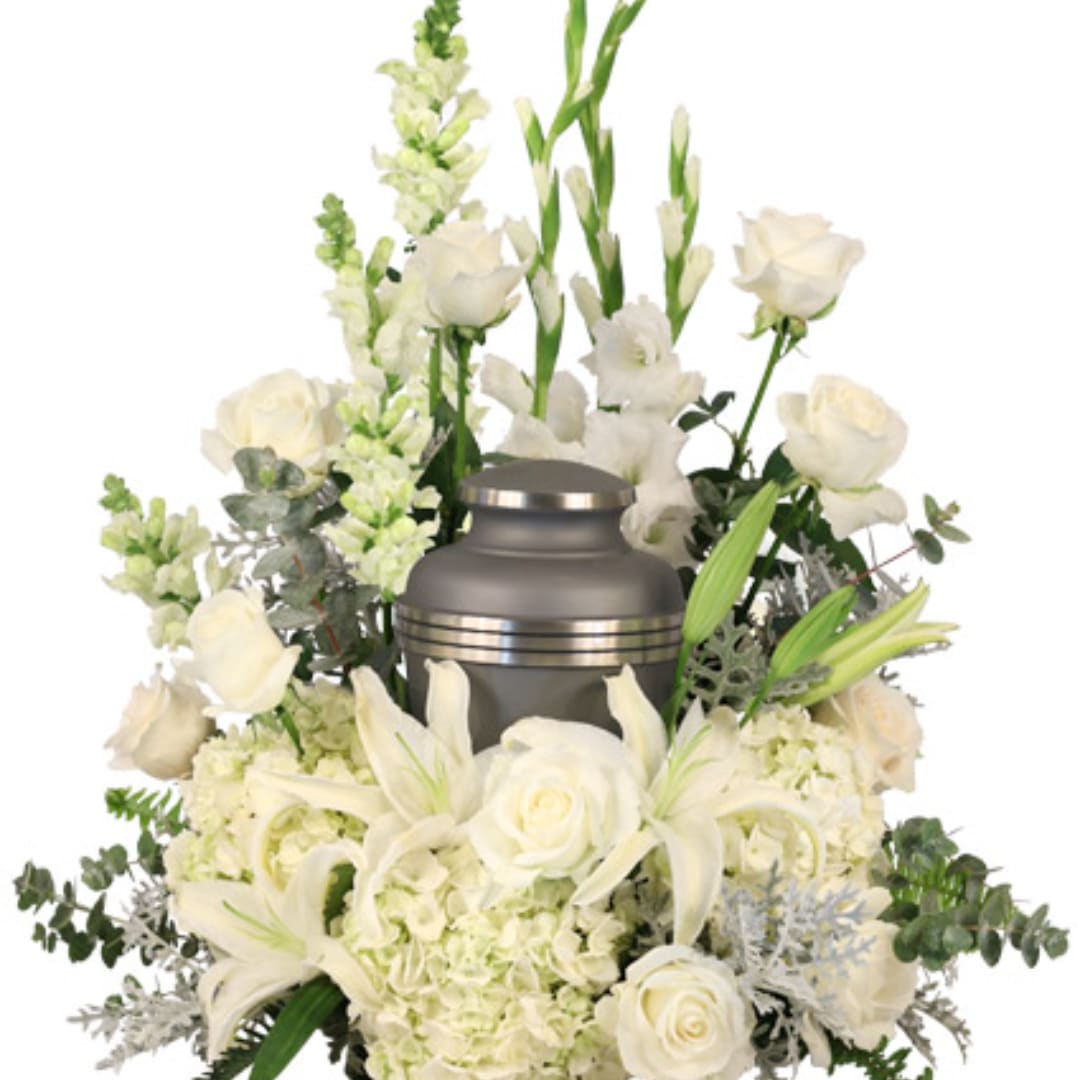 White funeral urn surrounded by white roses and lilies