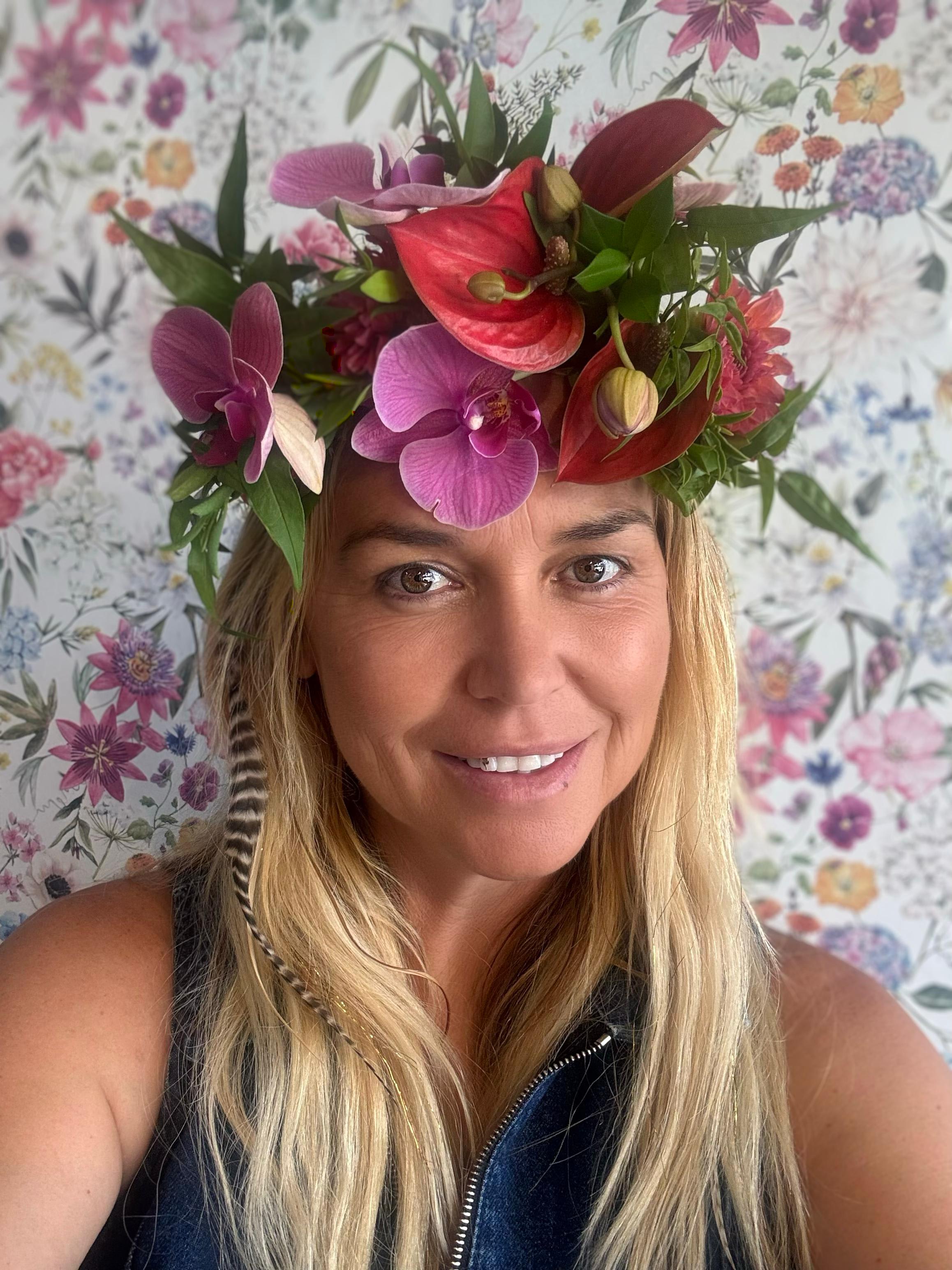 Woman wearing a floral crown with orchids and anthuriums