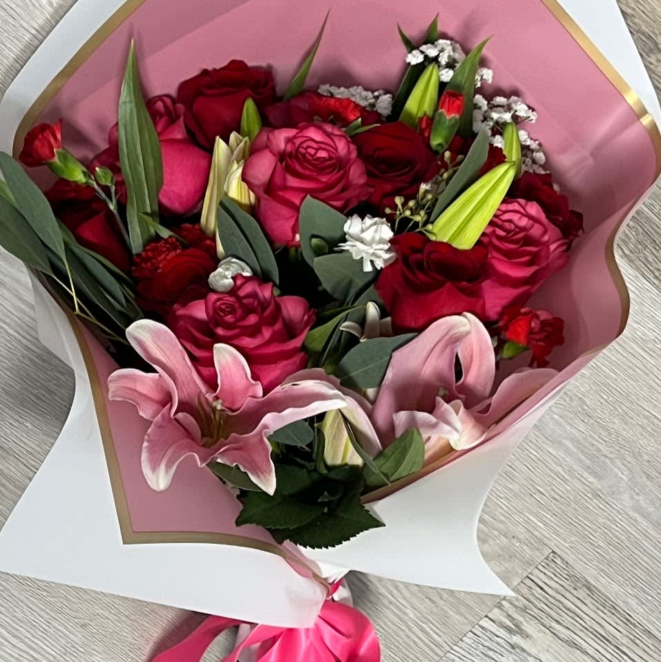 Bouquet of pink and red roses with pink lilies in paper wrap