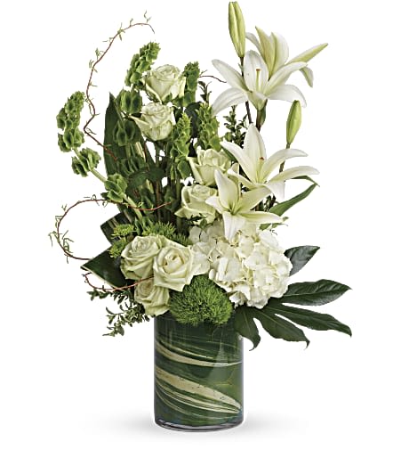 White lilies and roses arranged in a green glass vase