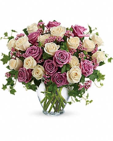 Pink and white roses arranged in a clear glass vase