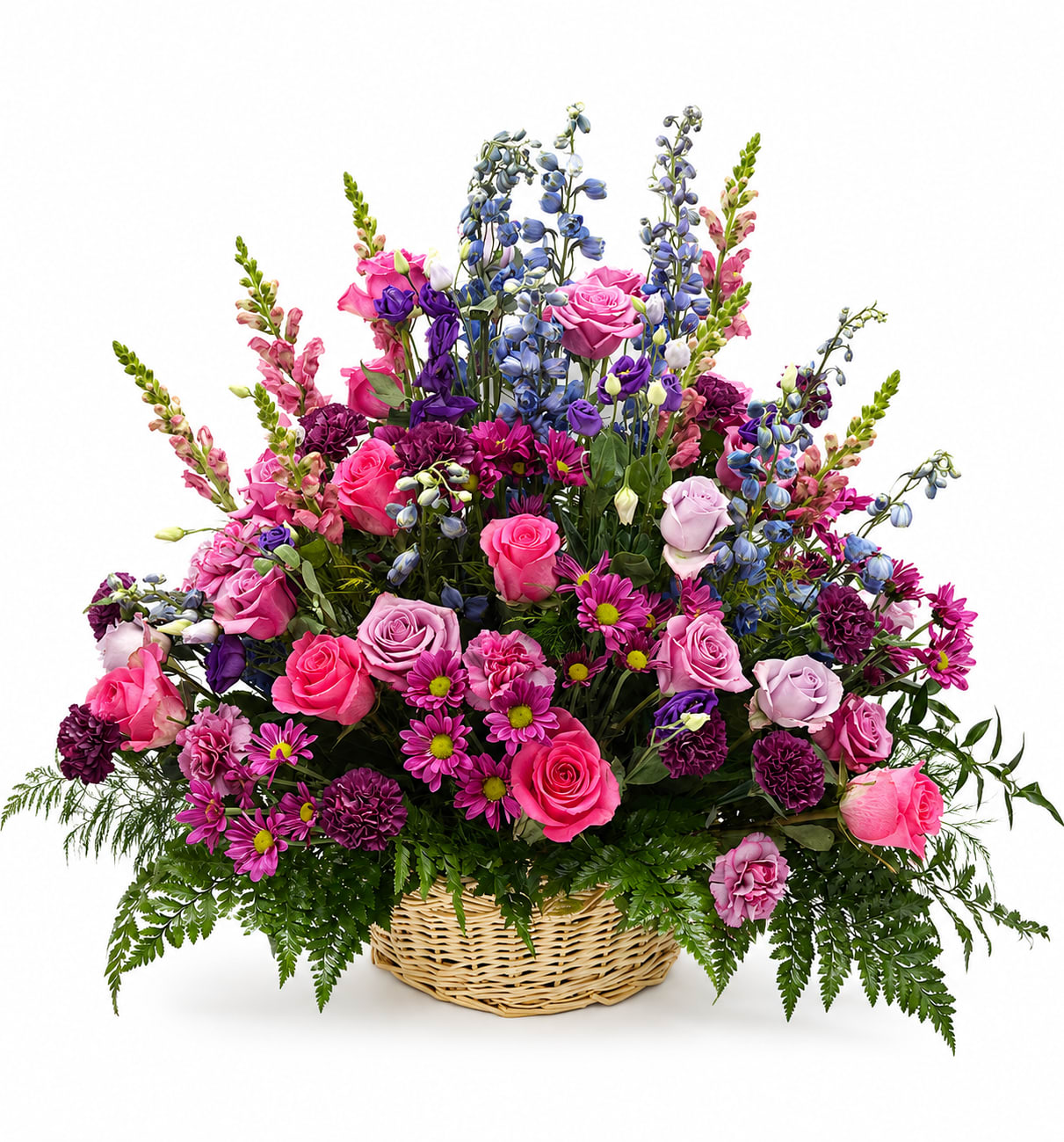 Blushing Garden Tribute Basket - Celebrate a beautiful life with the vibrant elegance of the Blushing Garden Tribute Basket. This abundant sympathy arrangement is thoughtfully handcrafted in a natural woven basket and features a stunning mix of premium pink roses, lavender roses, purple carnations, vivid daisy mums, blue delphinium, snapdragons, lisianthus, and lush seasonal greenery.  Designed in a graceful garden style, this arrangement combines soft pinks, rich purples, and cool blue accents to create a heartfelt expression of love, remembrance, and comfort. Its full, airy silhouette and premium blooms make it an exceptional choice for funeral services, memorial ceremonies, or as a thoughtful gesture sent directly to the family’s home.  Every arrangement is expertly crafted to honor cherished memories while bringing warmth, hope, and beauty during difficult times.  Key Features Premium pink and lavender roses Elegant blue delphinium and pink snapdragons Purple carnations and vibrant daisy mums Fresh lisianthus and seasonal greenery Designed in a classic woven basket for a timeless presentation Suitable for funeral services, memorials, and expressions of sympathy