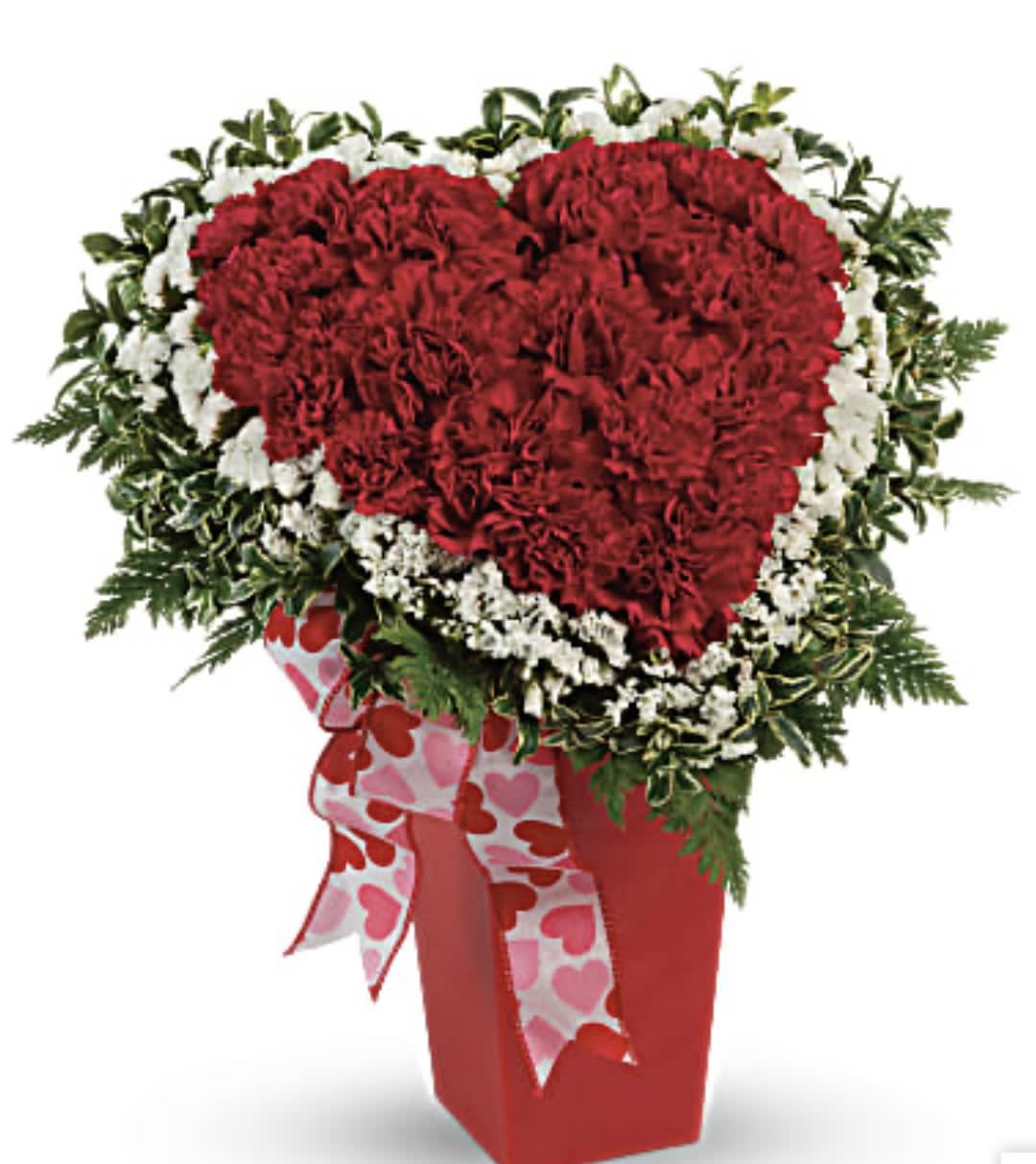 Heart-shaped red carnation arrangement with white flowers and a heart-print ribbon