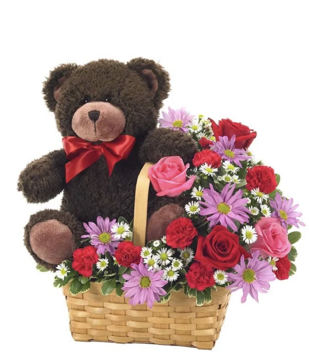 Teddy bear in a basket with mixed pink, red, and purple flowers