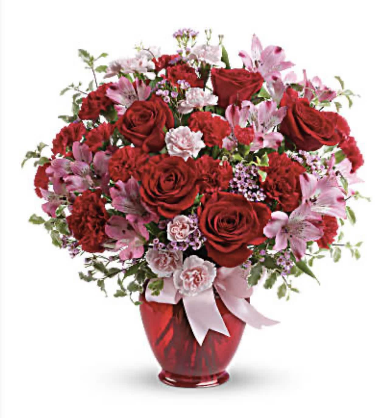 Red and pink flower arrangement in a red vase with a ribbon