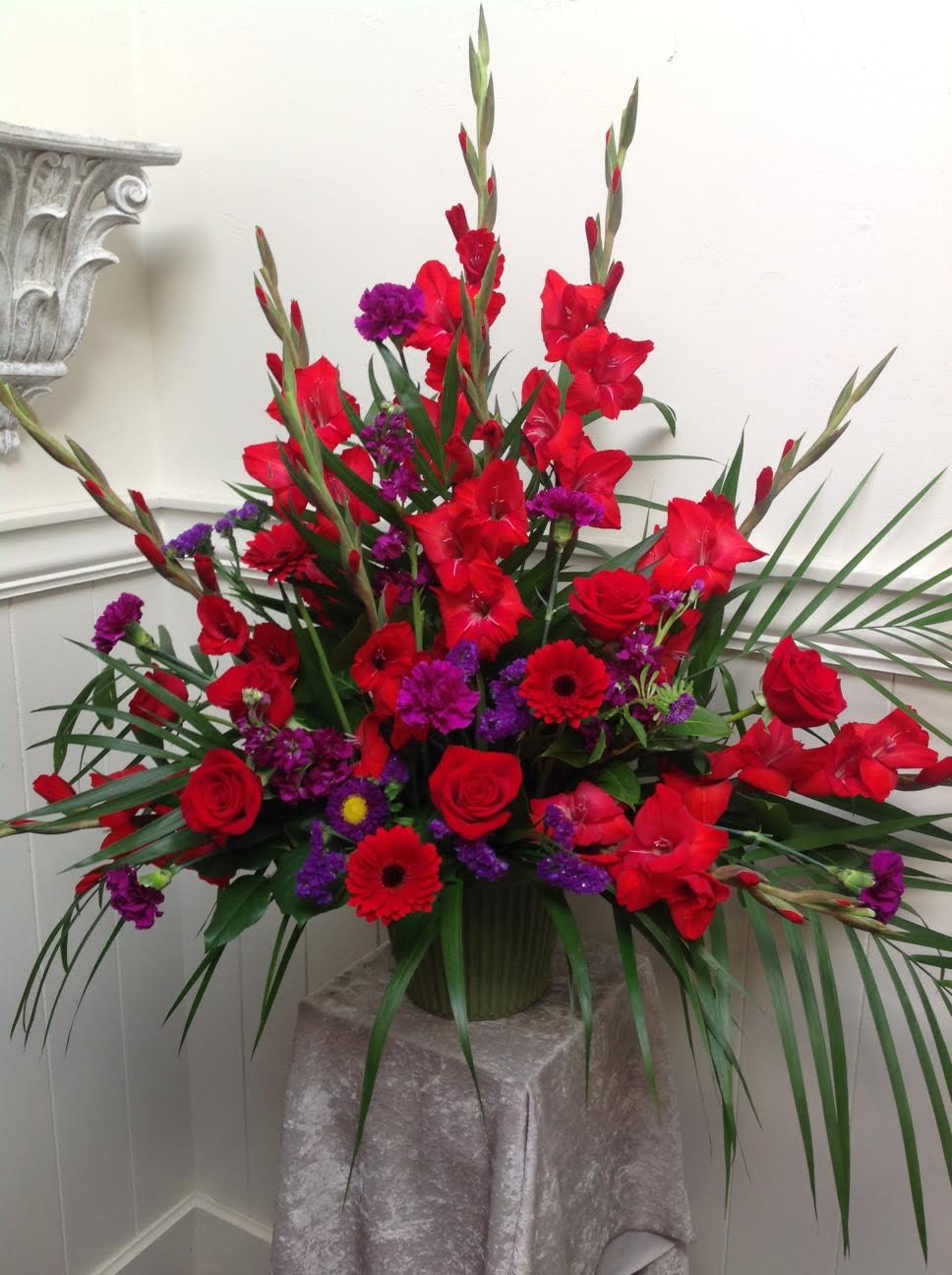 Tall red and purple floral arrangement in a vase