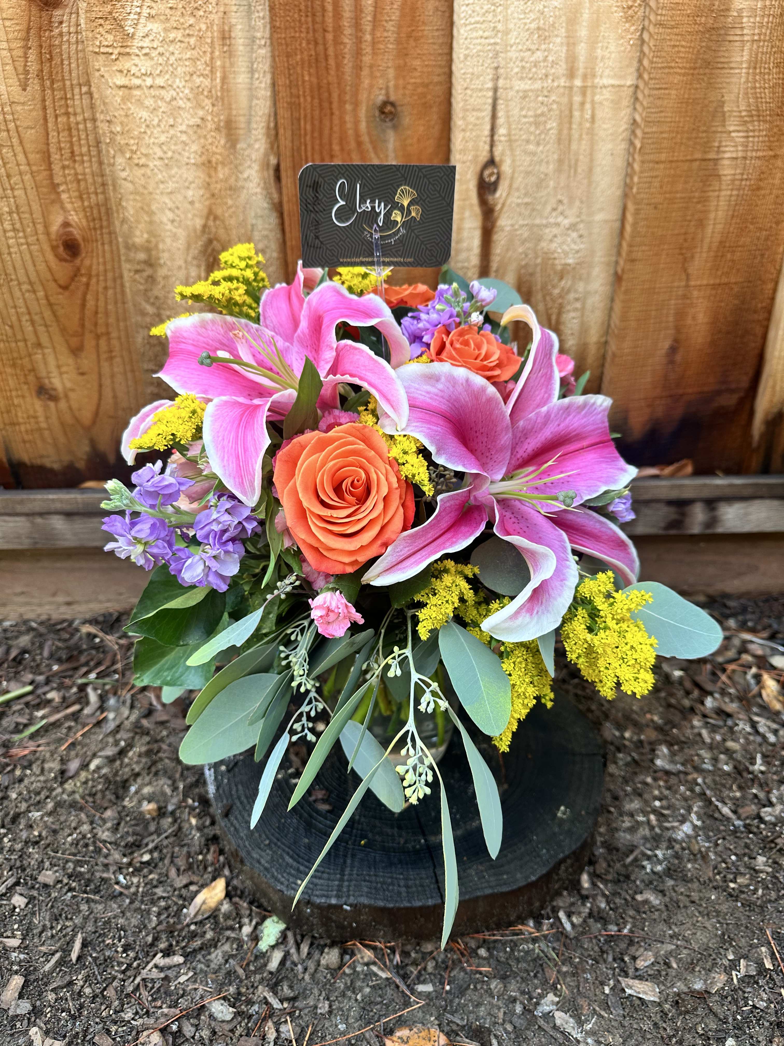 Bouquet of pink lilies and orange roses with purple flowers