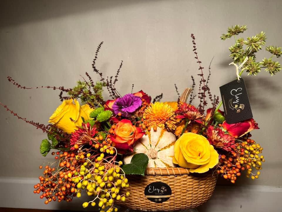 Colorful flower arrangement in a wicker basket with roses and berries
