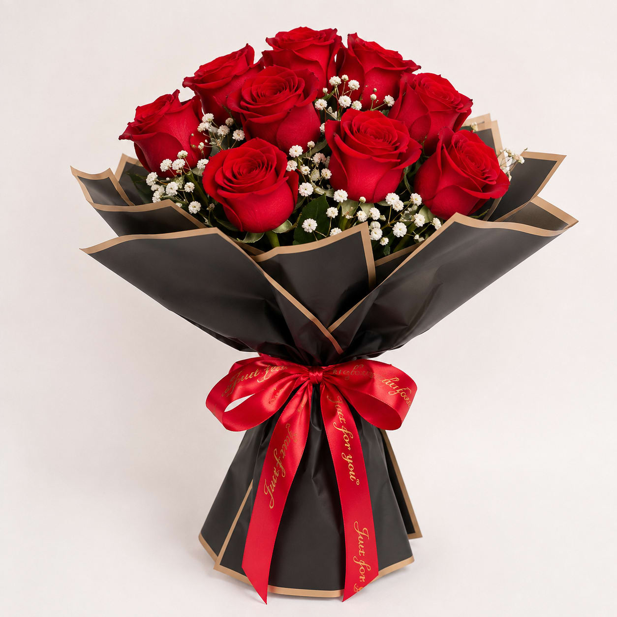 Bouquet of red roses with baby's breath wrapped in black paper and a red ribbon