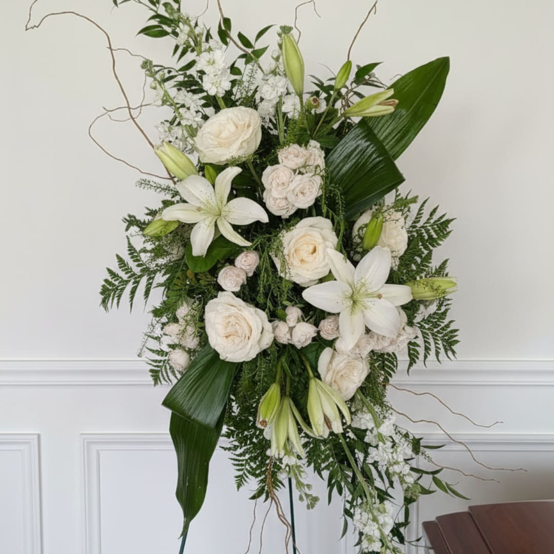 Tall white floral standing arrangement with lilies and roses