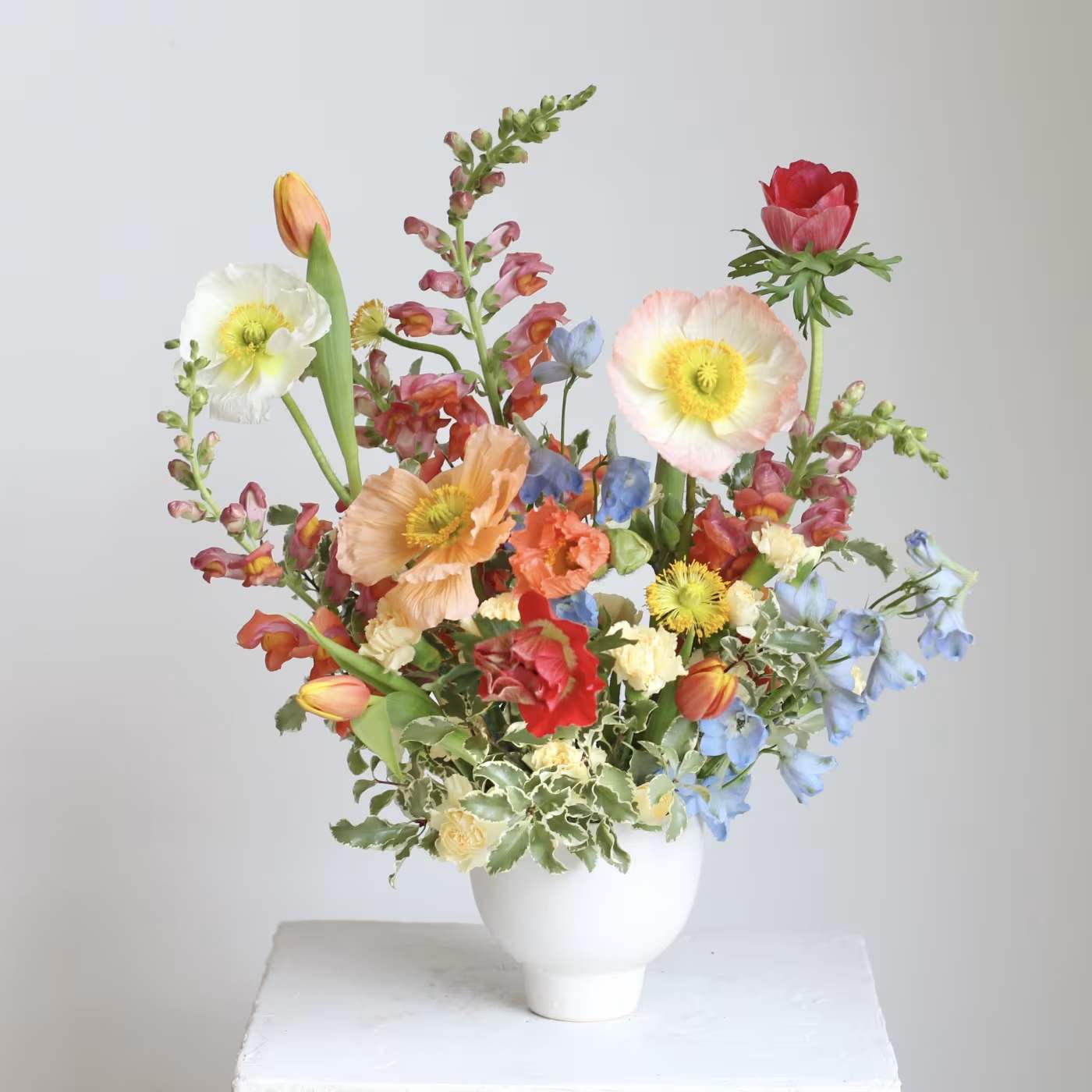 Colorful mixed flower arrangement in a white vase