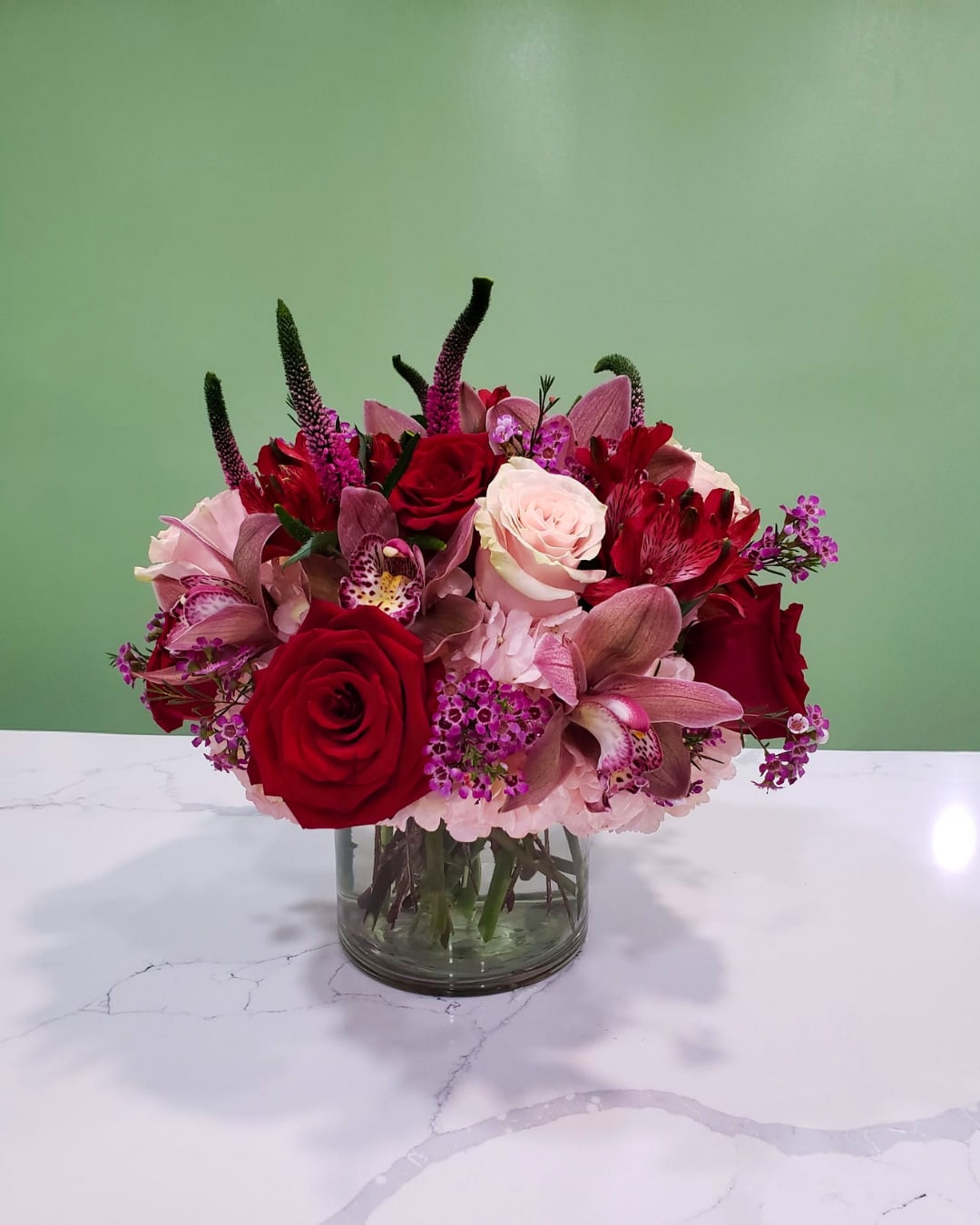 Mixed bouquet of red and pink roses in a glass vase