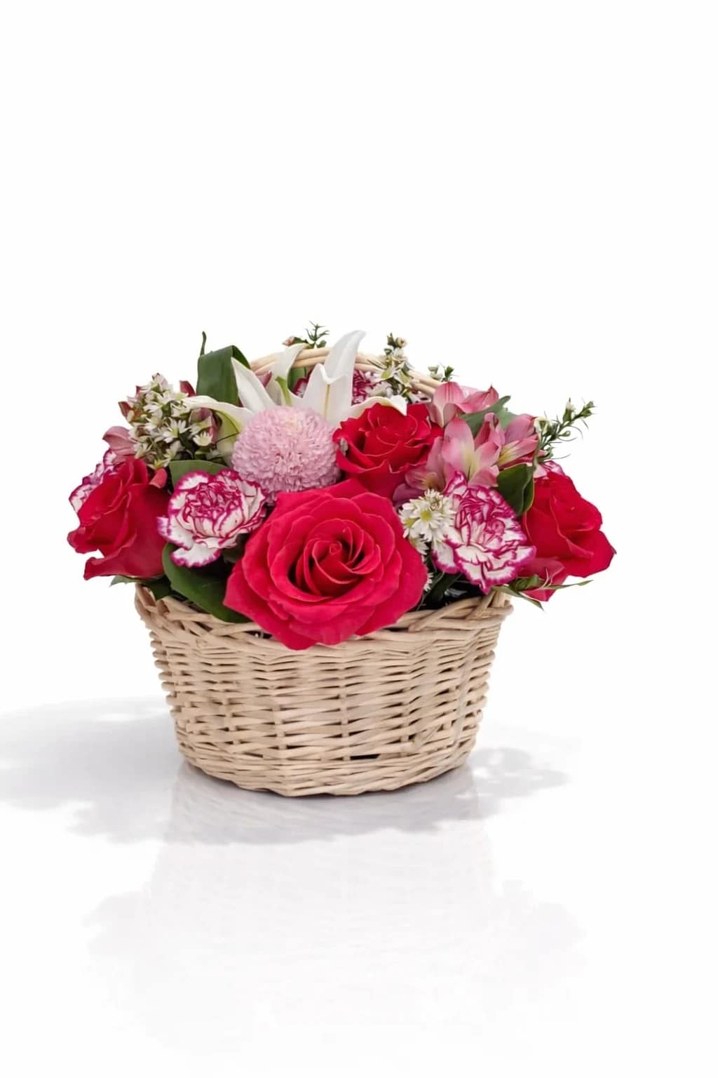 Basket of pink and red roses with white lilies and carnations