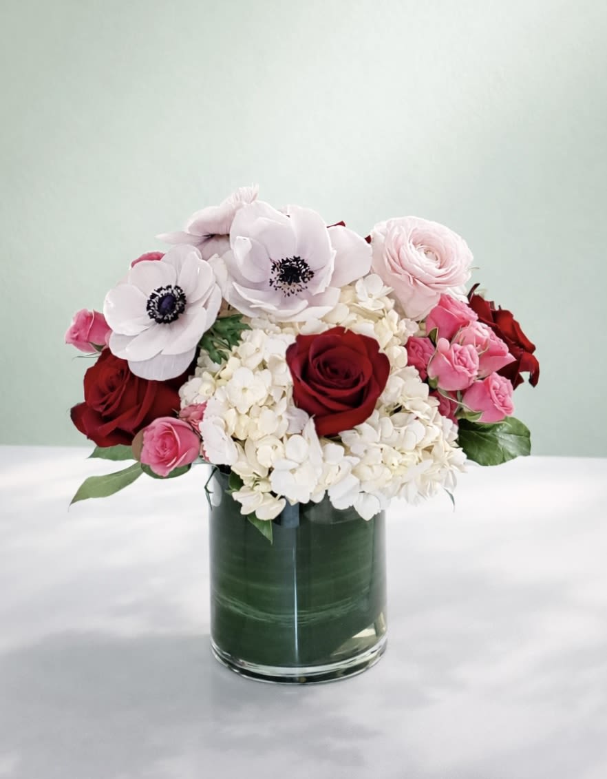 Anemone Kiss - This pretty mix of pink anemones, red roses, and fluffy white hydrangeas is perfect for bringing springtime romance into your home!