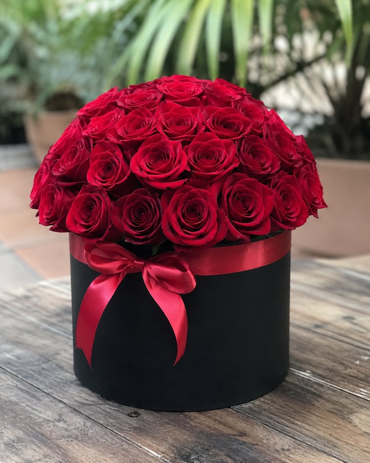 Red Elegance Box – 36 Roses - An elegant arrangement of 36 premium red roses beautifully designed in a sophisticated round black box accented with a delicate red ribbon. Its luxurious dome-shaped design makes it the perfect gift for anniversaries, birthdays, romantic occasions, or any special celebration. Flower shades and certain design details may vary based on seasonal availability.