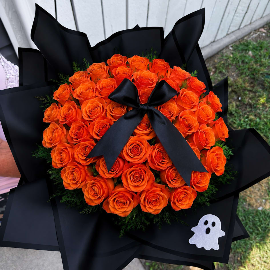 Bouquet of orange roses wrapped in black paper with a black ribbon