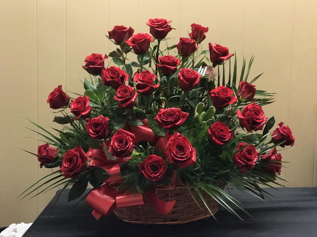 Basket arrangement of red roses with a red ribbon