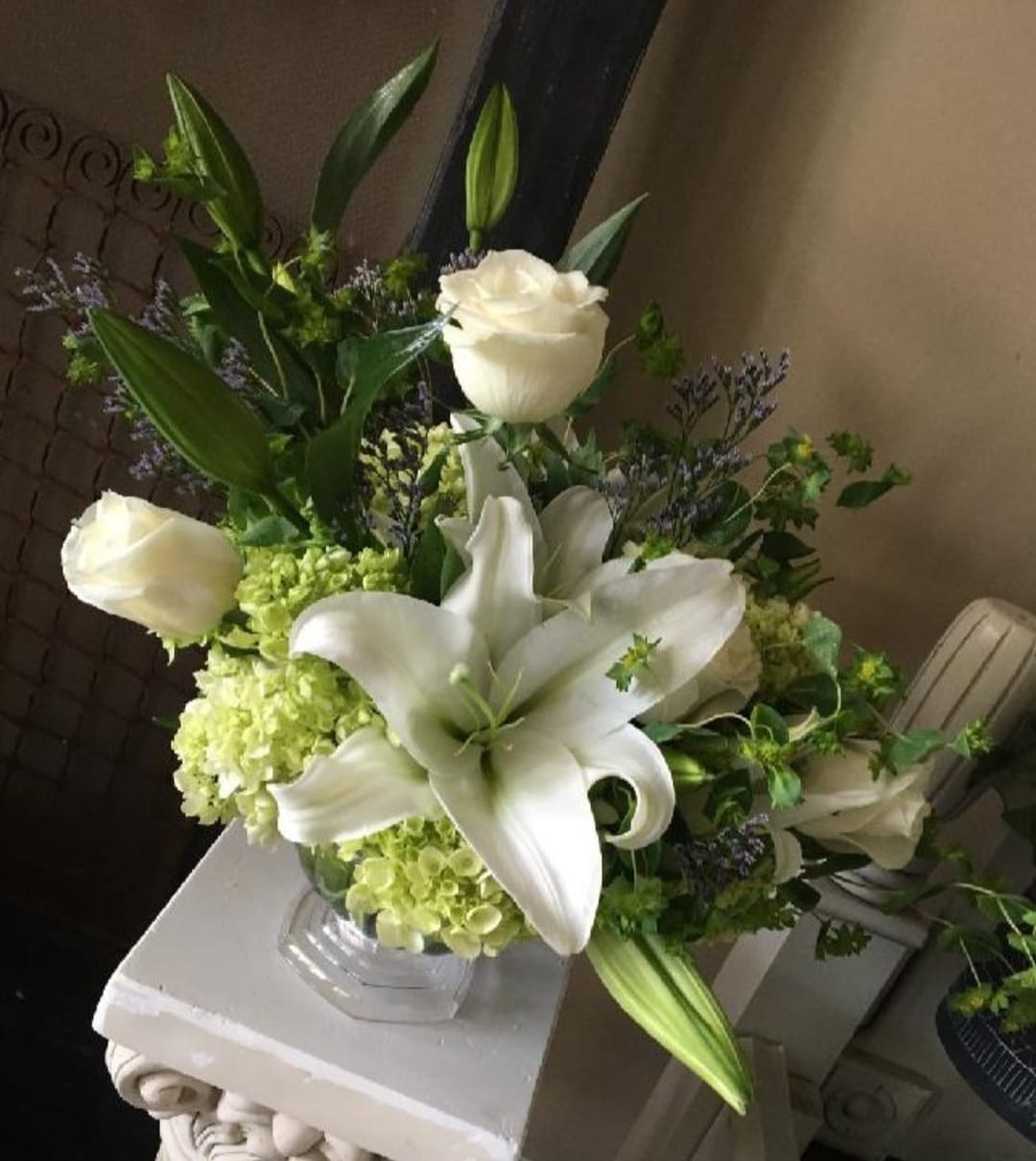 White lilies and roses arranged in a glass vase