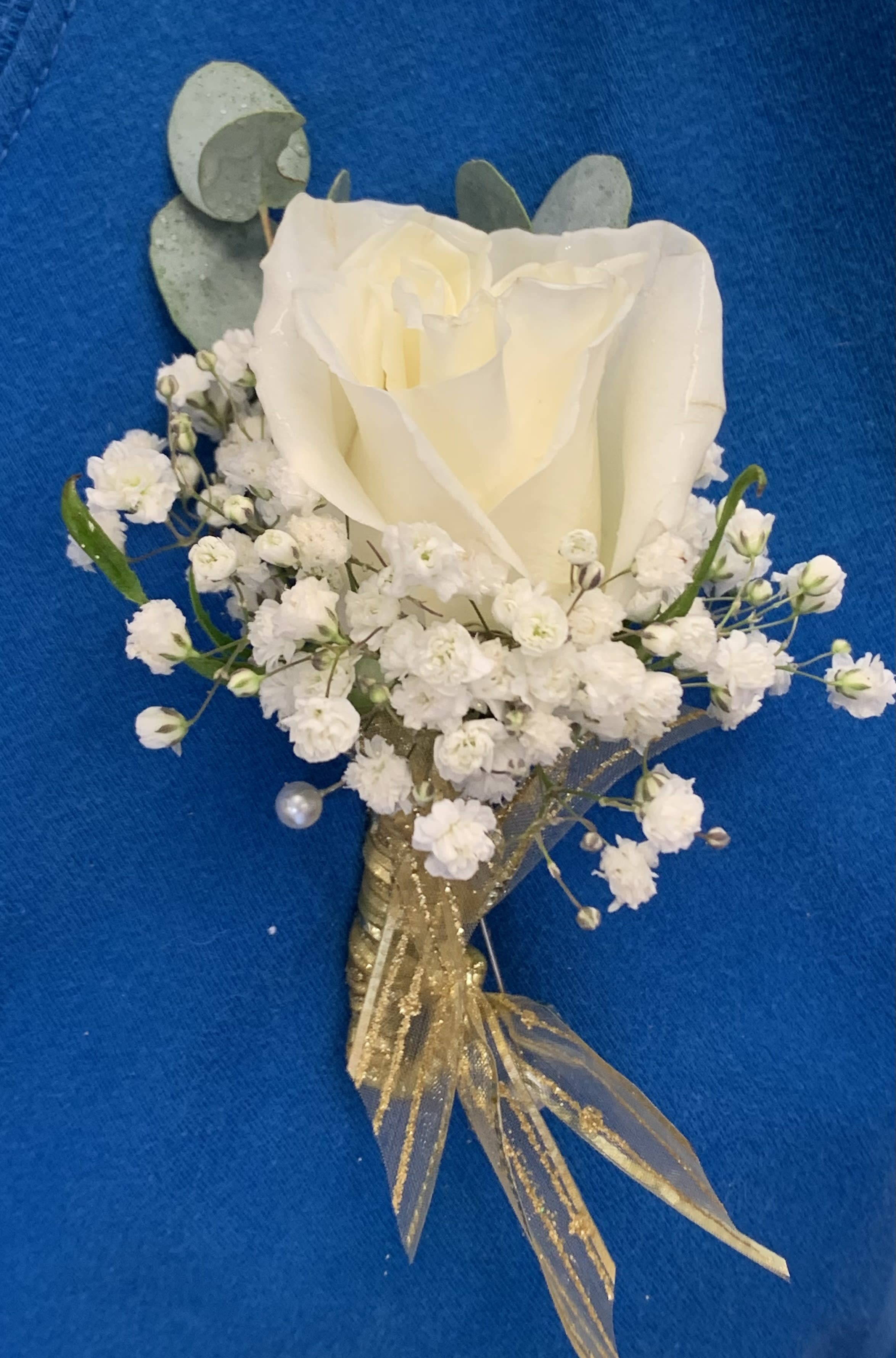 Rose Boutonnière by BloomNation™  - Available in Red White Pink or Yellow- Please note if you would like a special color of rose or ribbon-   If no instructions are made we will make as pictured-  A classic white boutonnière that compliments any suit. A perfect addition for any event.  One Full size White Rose, Babies, Breath, Touch of Greenery with Sparkling White/Irridescent Ribbon