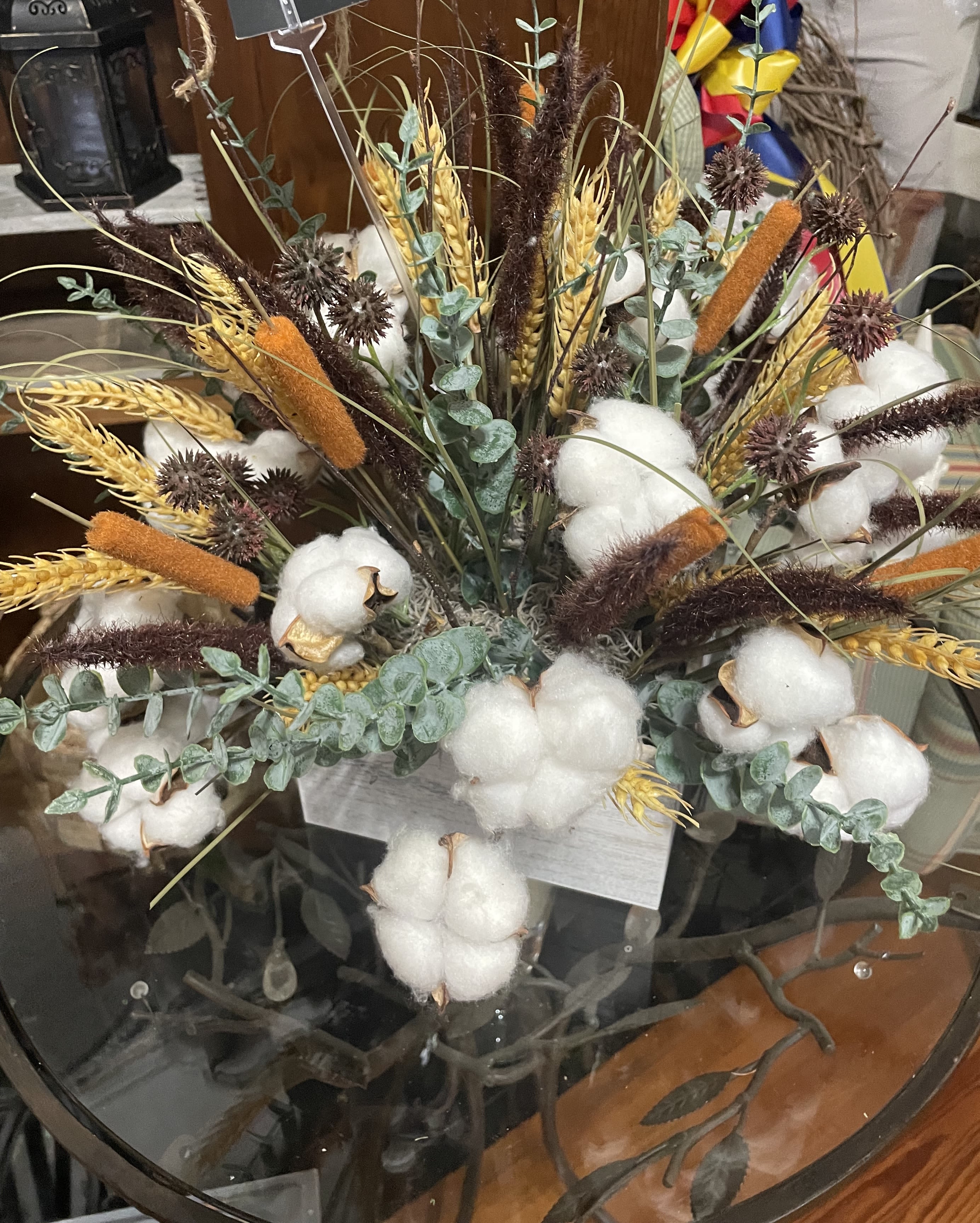 Arrangement of cotton bolls, wheat, and dried grasses in a container