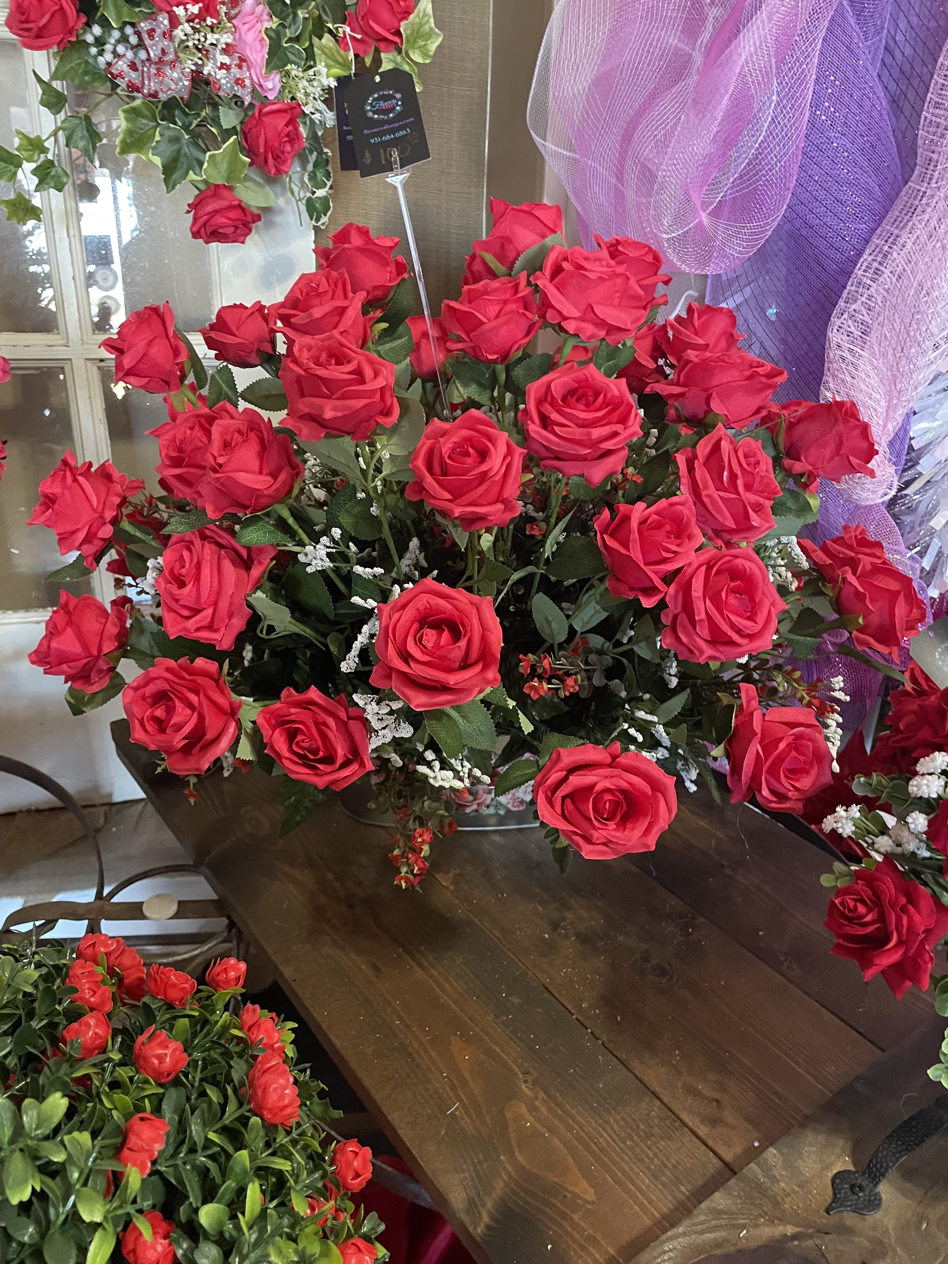 Large bouquet of bright red roses with purple mesh decor