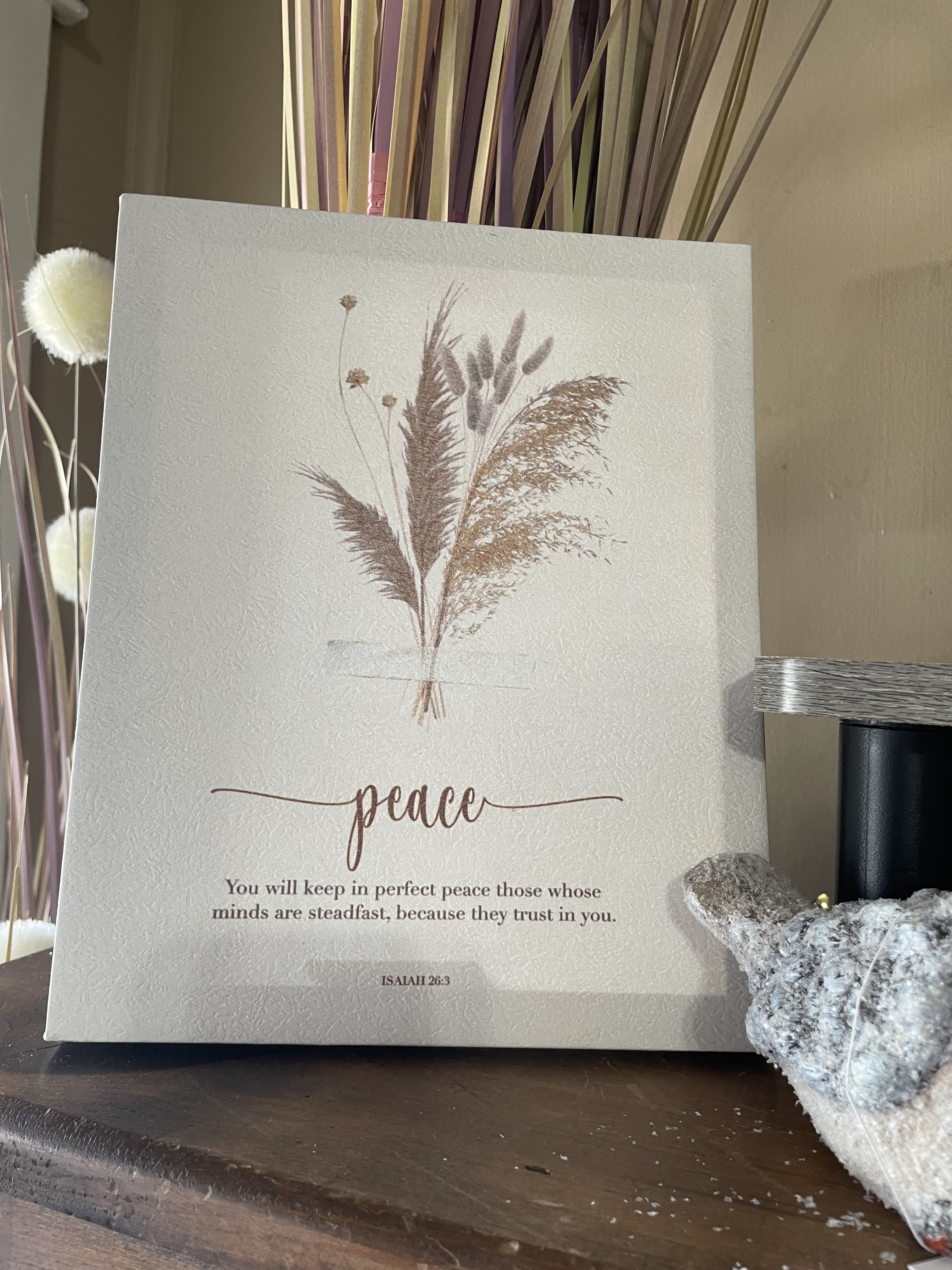 Decorative canvas with dried grasses and the word peace