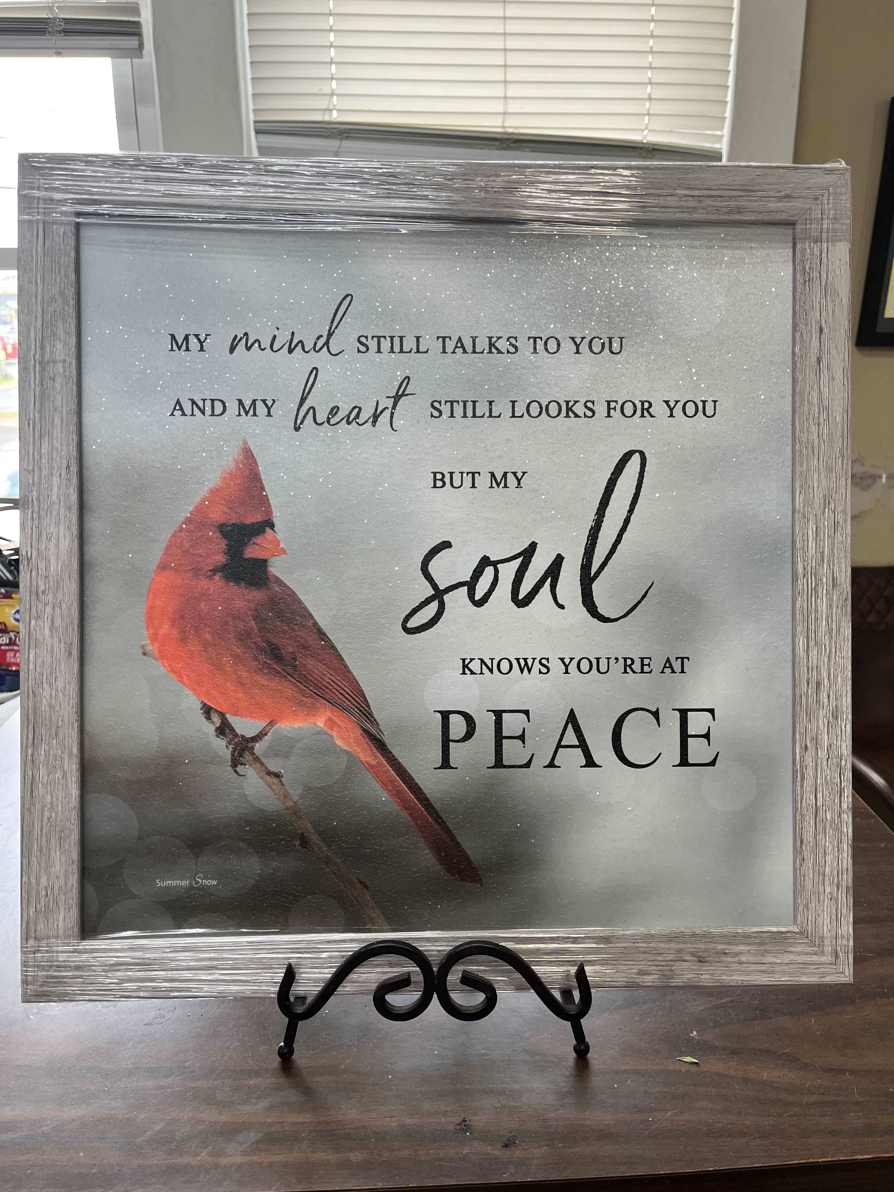Framed memorial sign with a red cardinal and peace message