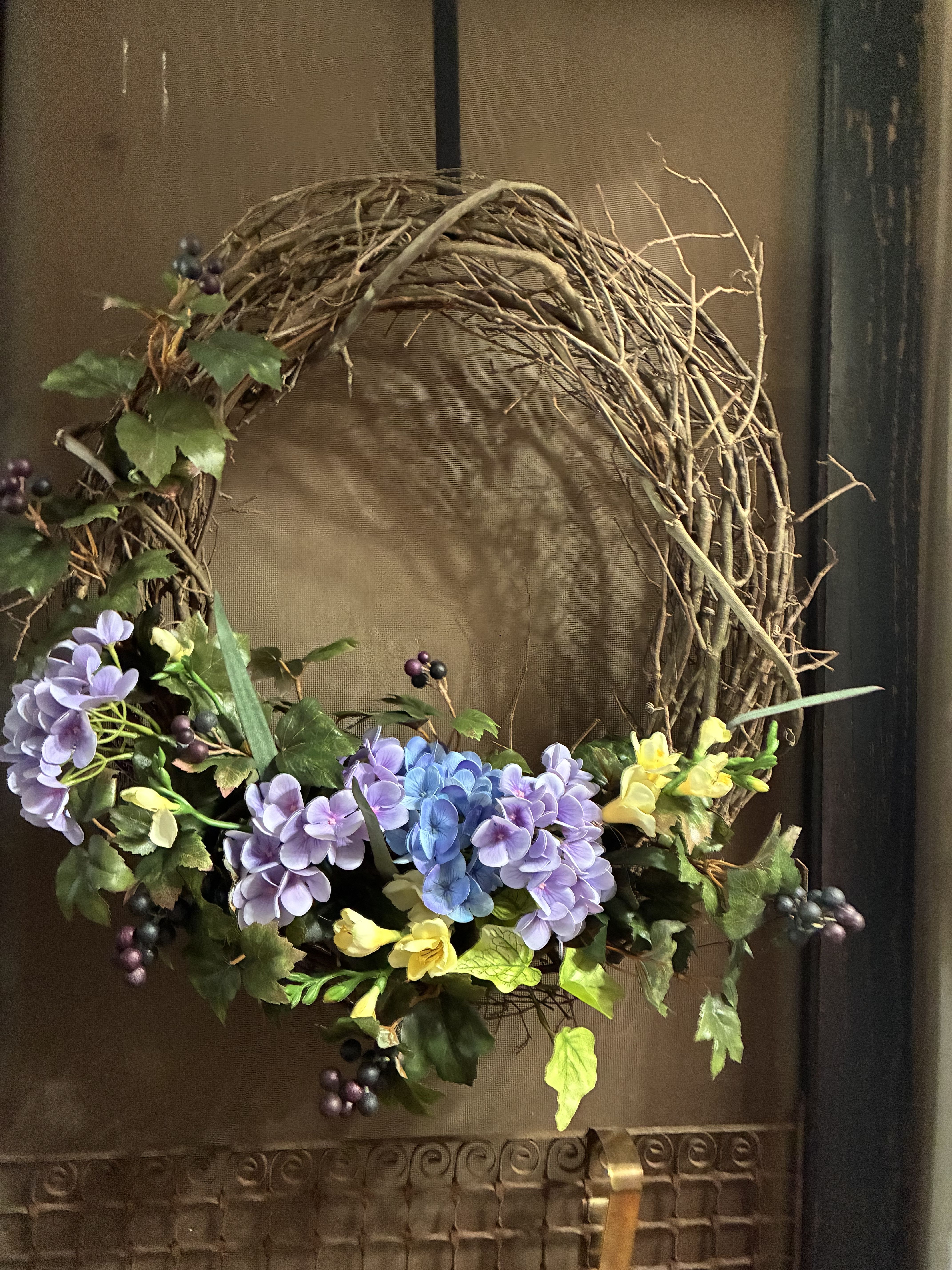 Purple Garden Silk Grapevine Wreath - A beautiful spring garden designed grapevine wreath. Just a lovely touch of silk florals made in all shades of purple with a silver accent ribbon and touches of blue florals.