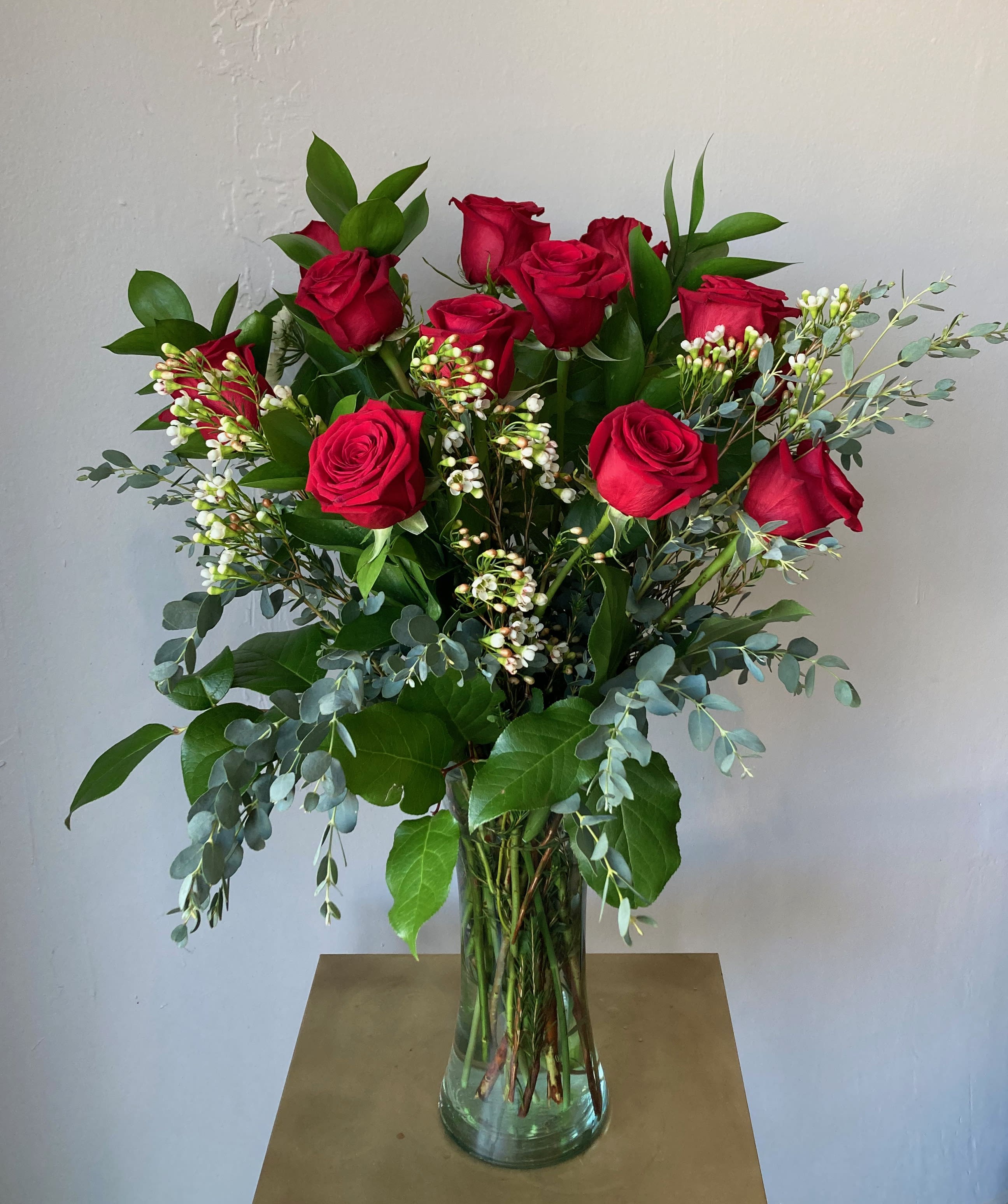 Tall bouquet of red roses in a clear glass vase