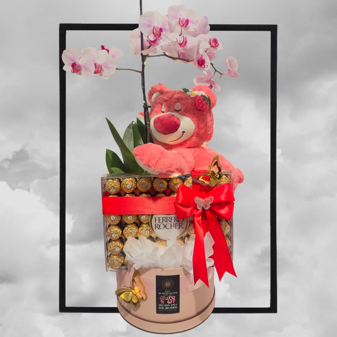 Pink orchid stems with a teddy bear and chocolate box gift arrangement