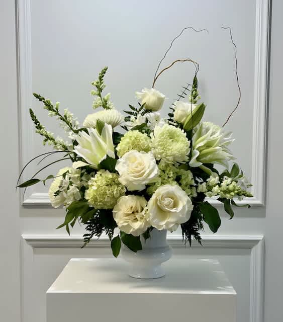White floral arrangement in a white pedestal vase