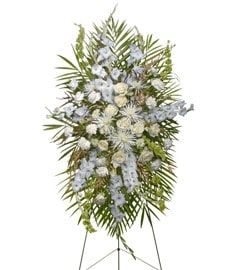 White and pale blue funeral spray on a standing easel