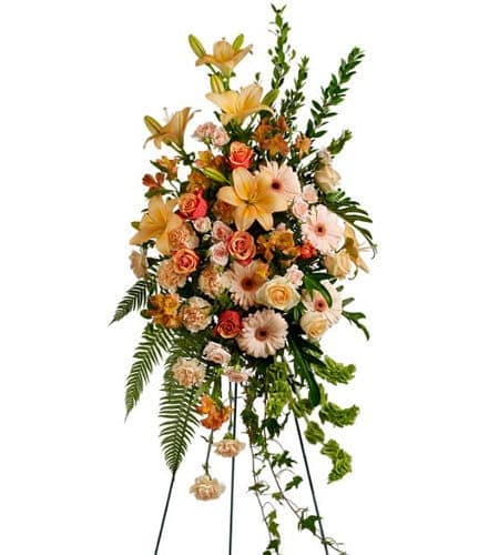 Tall standing floral spray with peach and pink flowers on a metal easel