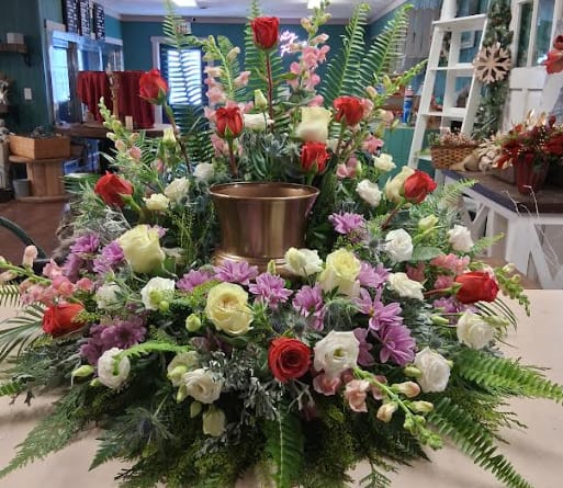 Large floral centerpiece with red and white roses around a gold vase