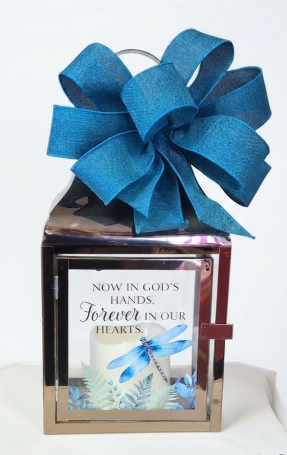 Decorative memorial lantern with a large blue bow and sympathy message