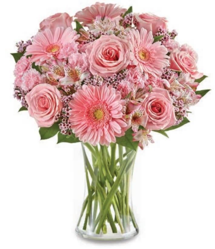 Pink roses and gerbera daisies in a clear glass vase