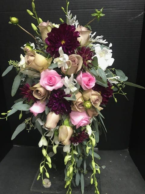 Bouquet of pink and beige roses with dark purple blooms