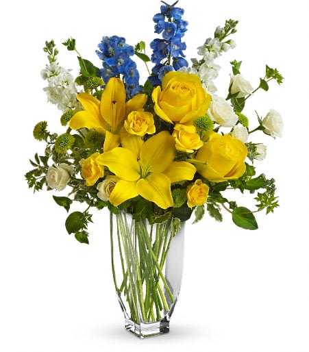 Yellow lilies and roses with blue and white flowers in a clear vase
