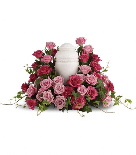 Pink roses arranged around a white urn