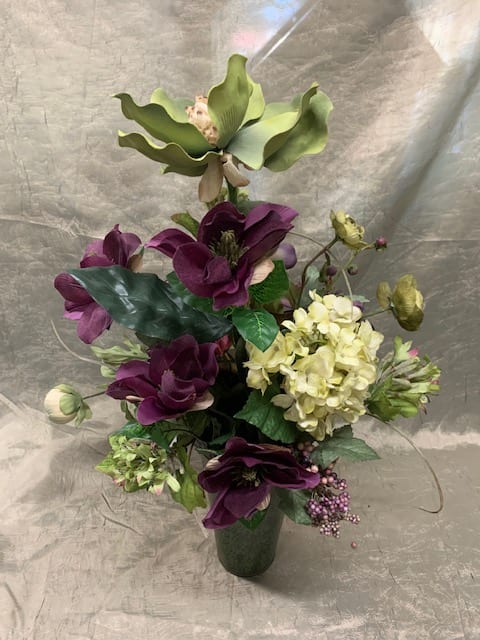 Purple and cream floral arrangement in a dark vase
