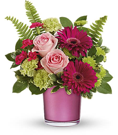 Pink roses and magenta gerberas in a pink glass vase