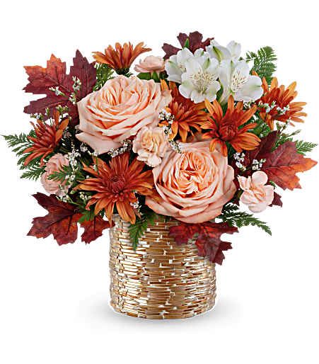 Autumn bouquet of peach roses and orange daisies in a woven basket