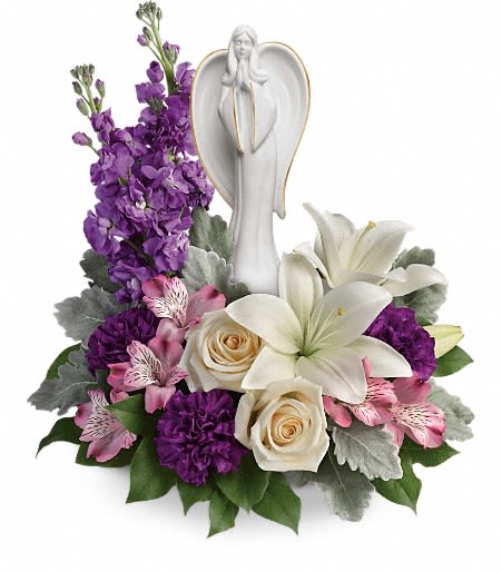 Purple and white floral arrangement with an angel figurine
