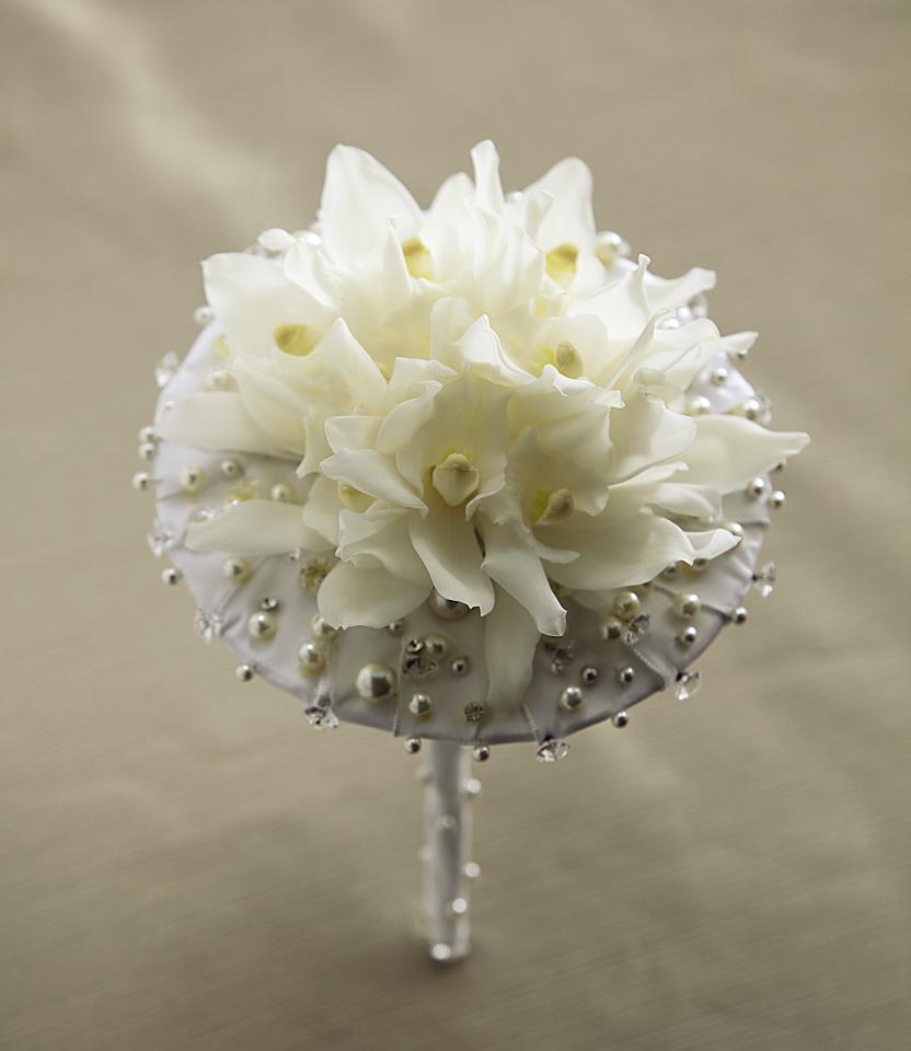 FTD Pure at Heart Bouquet - The FTDÂ® Pure at Heartâ¢ Bouquet is blooming with sweet innocence with  its delicate design. Gorgeous white mini cymbidium orchids are arranged  to perfection amidst an intricate flower bracelet detailed with pearls  and sparkling accents. Finished with an ivory satin ribbon on the stems,  this beautiful bouquet is set for the bride with a modern flair.  Approx. 6-inches in diameter. 