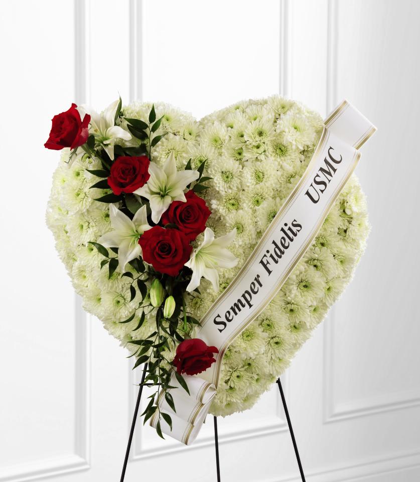 FTD Salute to a Patriot Standing Heart - The FTD Salute to a Patriot Standing Heart is the perfect tribute  to a fallen marine. A pearly white heart consisting of chrysanthemums  is accented with an arrangement of red roses, white Asiatic lilies and  lush greens, as well as, a white banner that reads, ""Semper Fidelis  USMC,"" to create an incredible presentation at their final memorial  service. Displayed on a wire easel.   24""h x 24""w