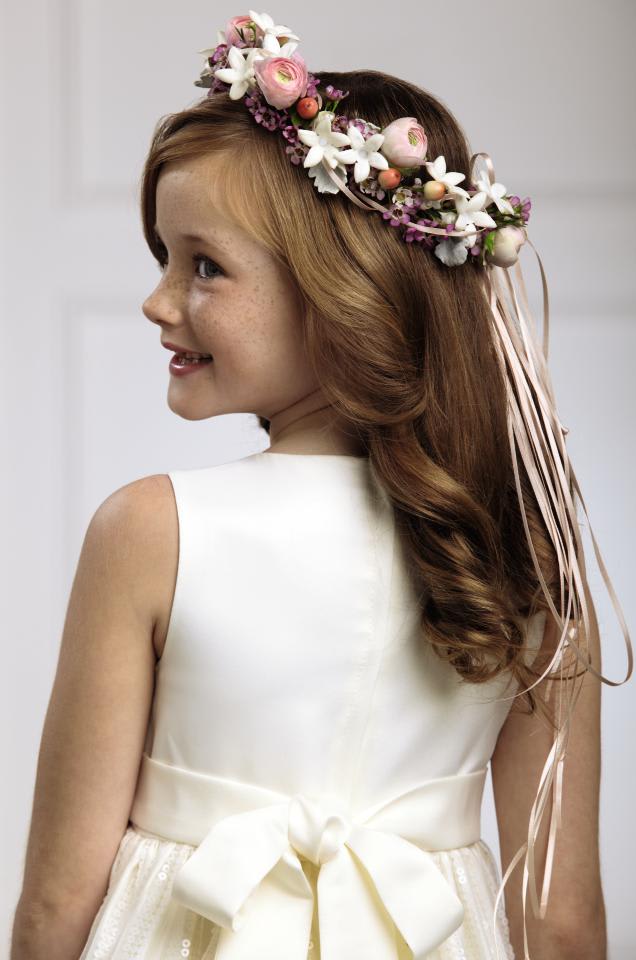 FTD Lila Rose Hairpiece - The FTD Lila Rose Headpiece will make any flower girl glow. Pink  ranunculus, white stephanotis blooms, pink waxflower, peach hypericum  berries and dusty miller stems are arranged in the perfect circle and  accented with peach satin ribbon to crown her head on the wedding day,  giving your flower girl a sweet look for her big moment. Approx.  8-inches in diameter. 