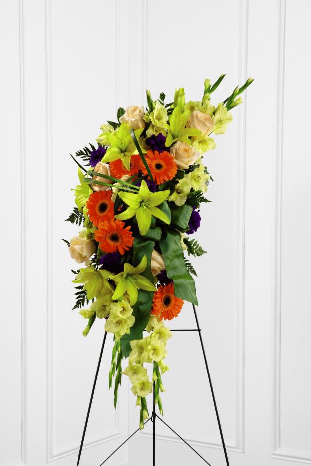 FTD Heaven's Light Standing Spray - The FTD Heaven's Light Standing Spray is a bright and brilliant  tribute that offers warmth and hope. Sunny yellow gladiolus and Asiatic  lilies are offset by creme de la creme roses, orange gerbera daisies,  purple lisianthus, green button poms and lush greens. Accented with a  designer sea mist green wired taffeta ribbon and displayed on a wire  easel, this beautiful standing spray will be a ray of light to honor the  deceased and bring comfort to friends and family.  48h x 16w