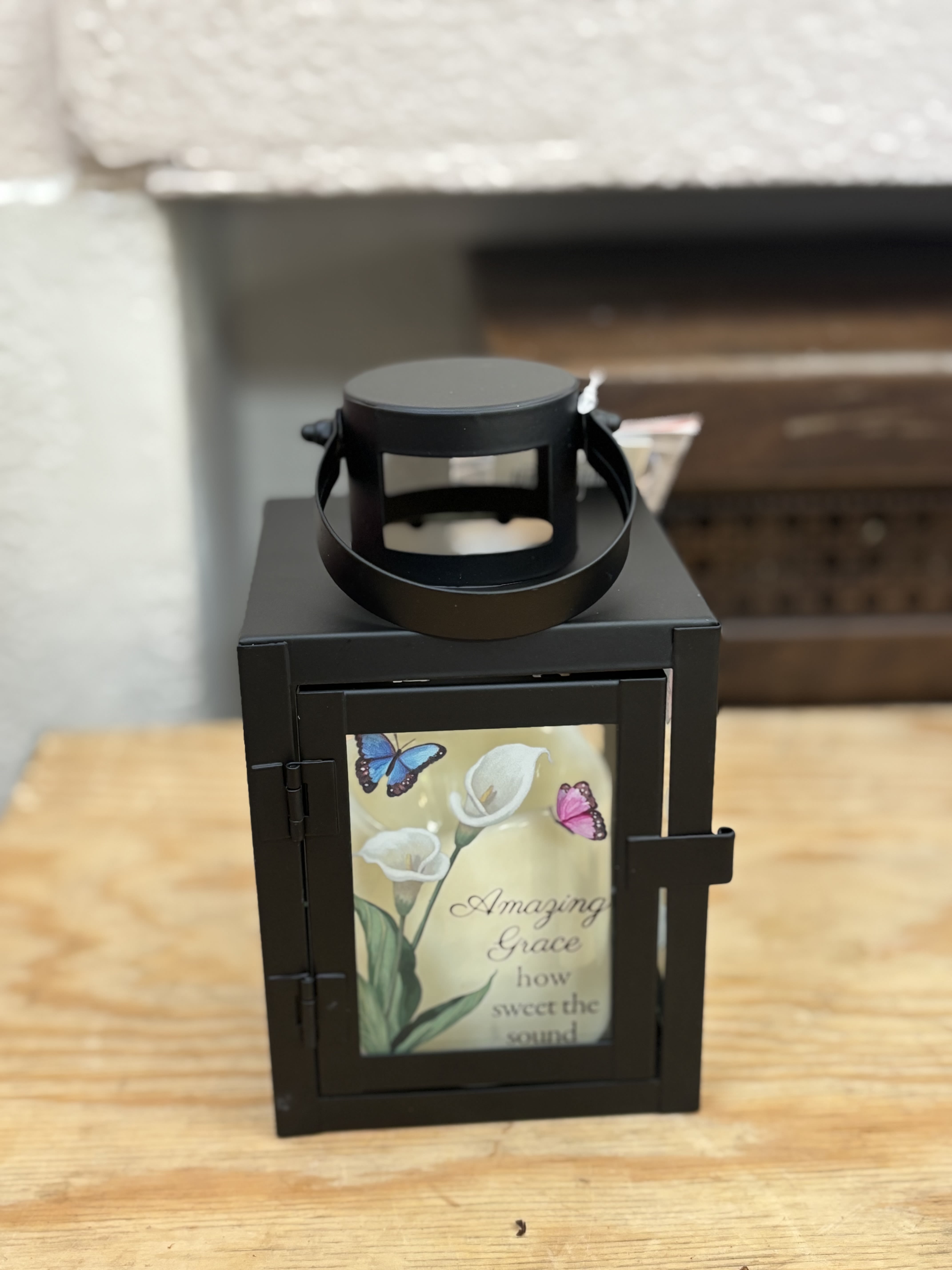 Black lantern with a floral memorial-style insert and butterflies