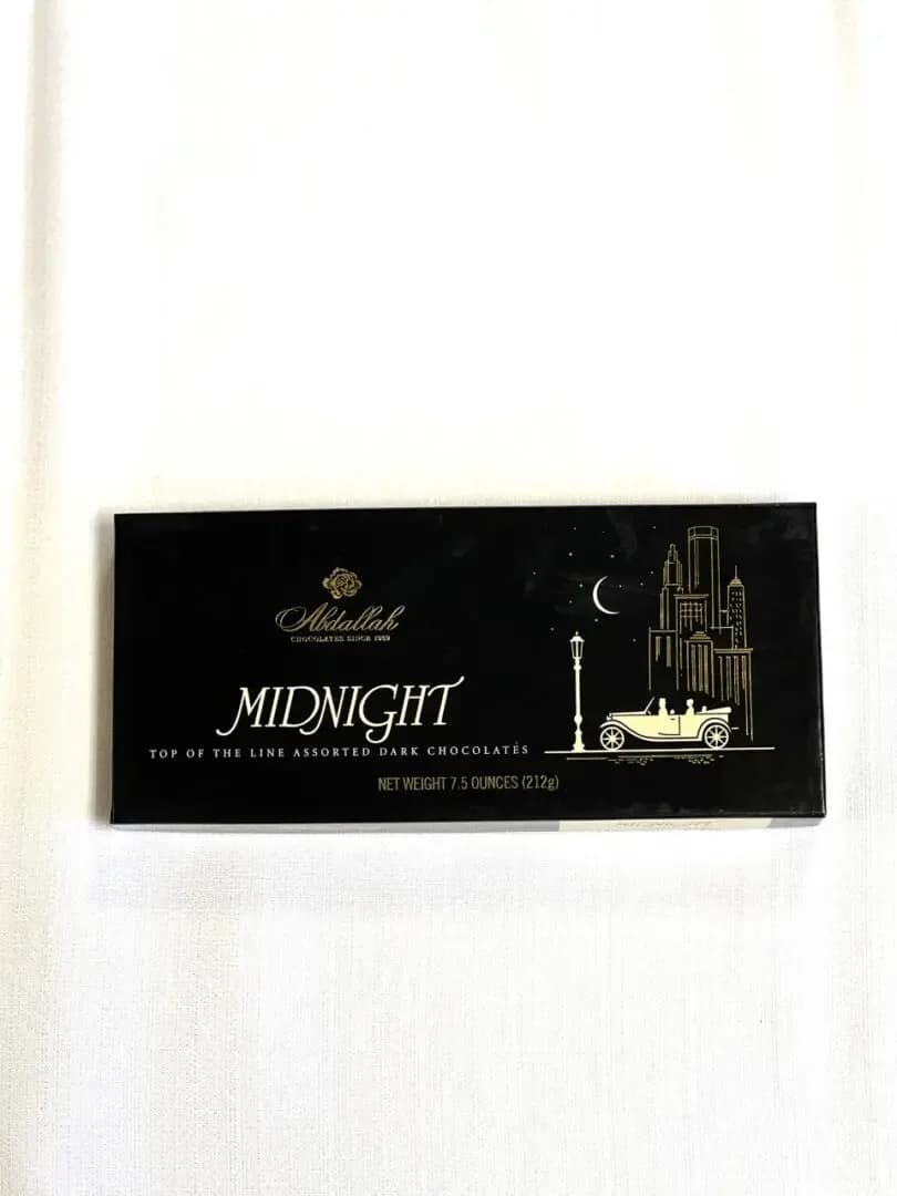 Box of assorted dark chocolates on a white surface