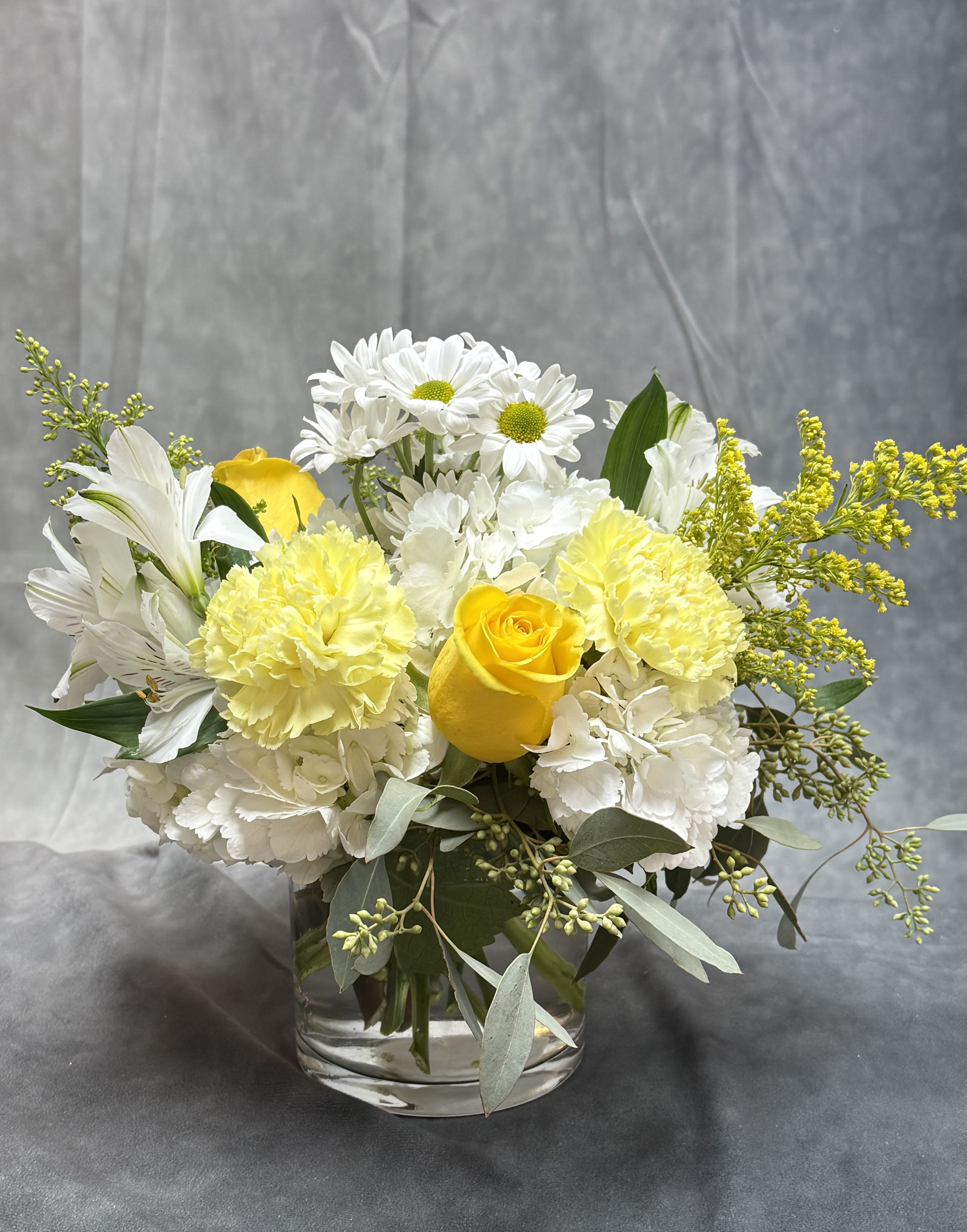 Yellow and white bouquet in a clear glass vase